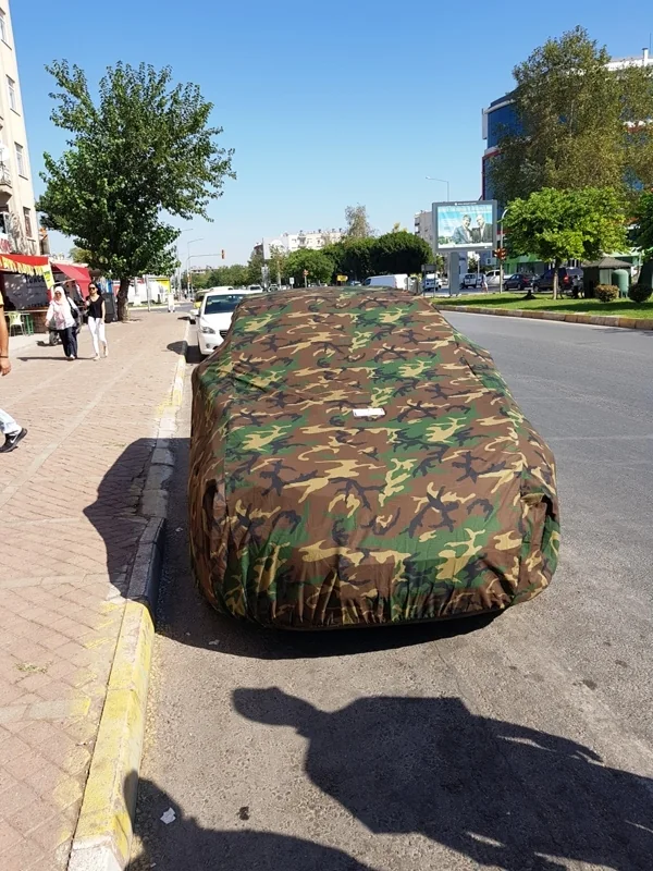 Kamuflaj desenli araba çadırı ile örtülmüş park hâlindeki araç